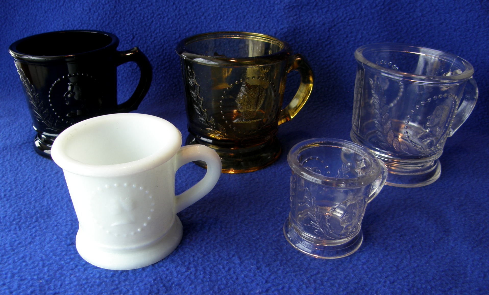 Five Medallion mugs, three large (black, clear, amber), one medium (white), one small (clear)