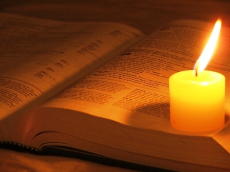 Bible Lighted by Votive Candle
